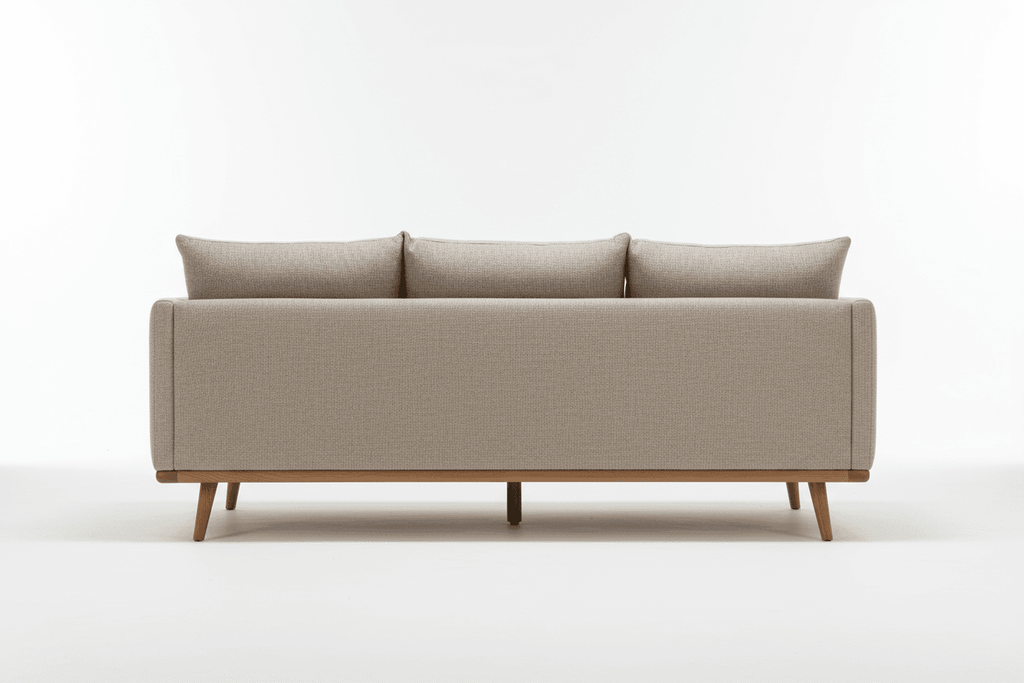 The back view of a neutral-colored ottoman sofa with wooden legs.